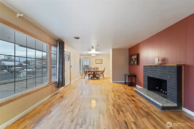a view of a livingroom with wooden floor and a fireplace