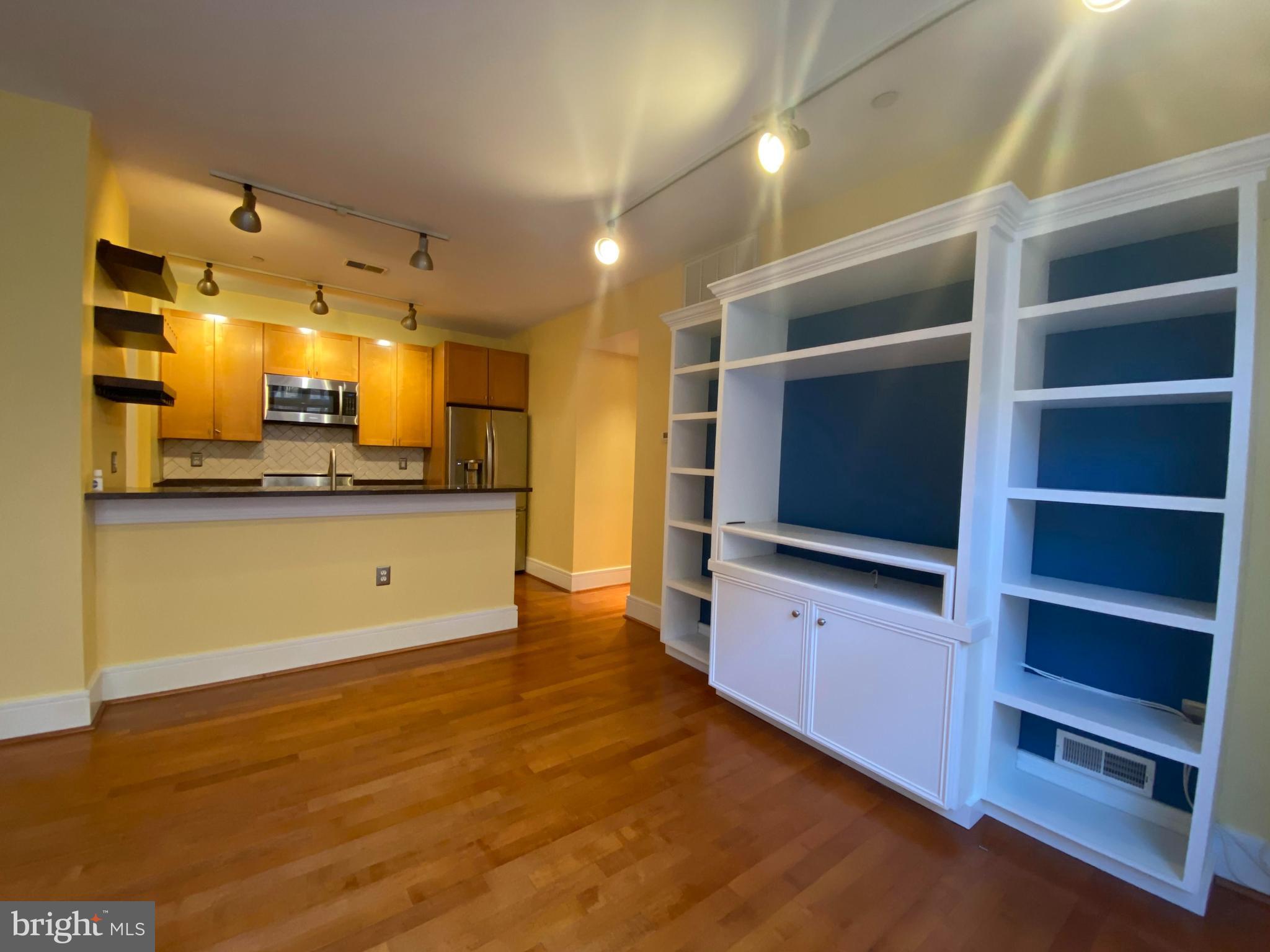 1654 Euclid Street Northwest, Unit 105 Washington, DC 20009 - Photo 11 of 29 a kitchen with stainless steel appliances kitchen island granite countertop a stove and a microwave