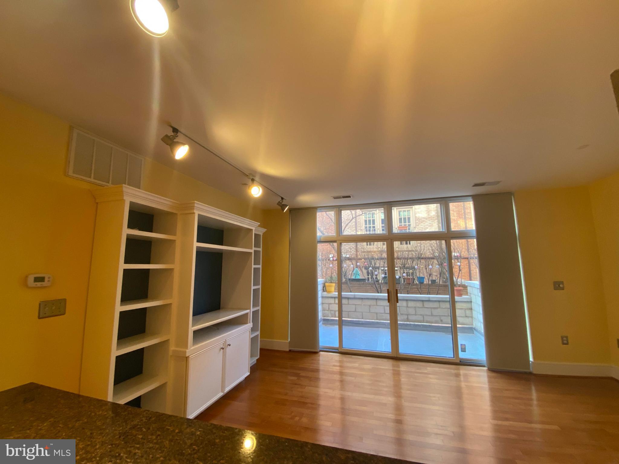 1654 Euclid Street Northwest, Unit 105 Washington, DC 20009 - Photo 14 of 29 a view of an empty room with wooden floor and a window
