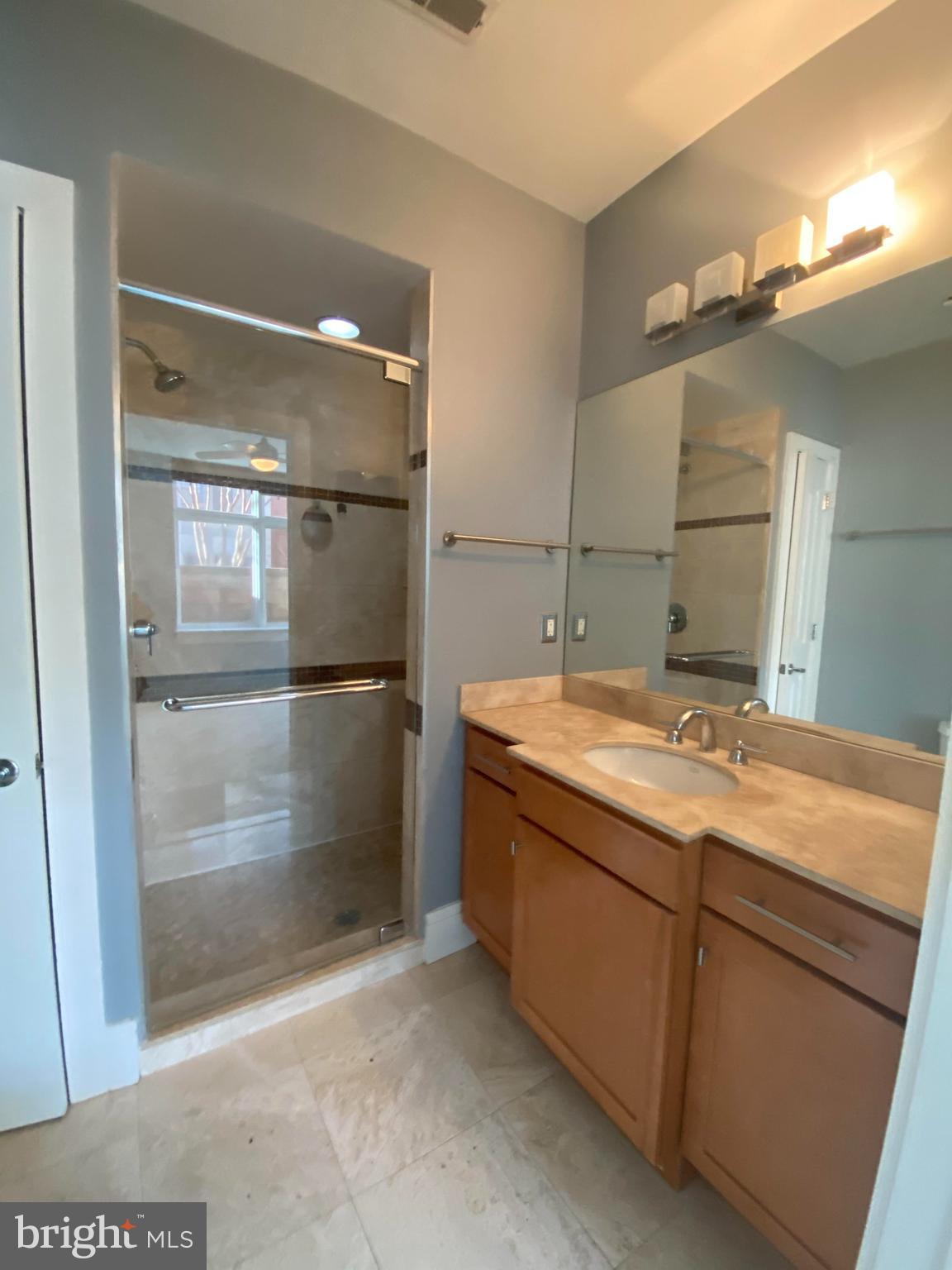 1654 Euclid Street Northwest, Unit 105 Washington, DC 20009 - Photo 20 of 29 a bathroom with a granite countertop sink mirror and shower
