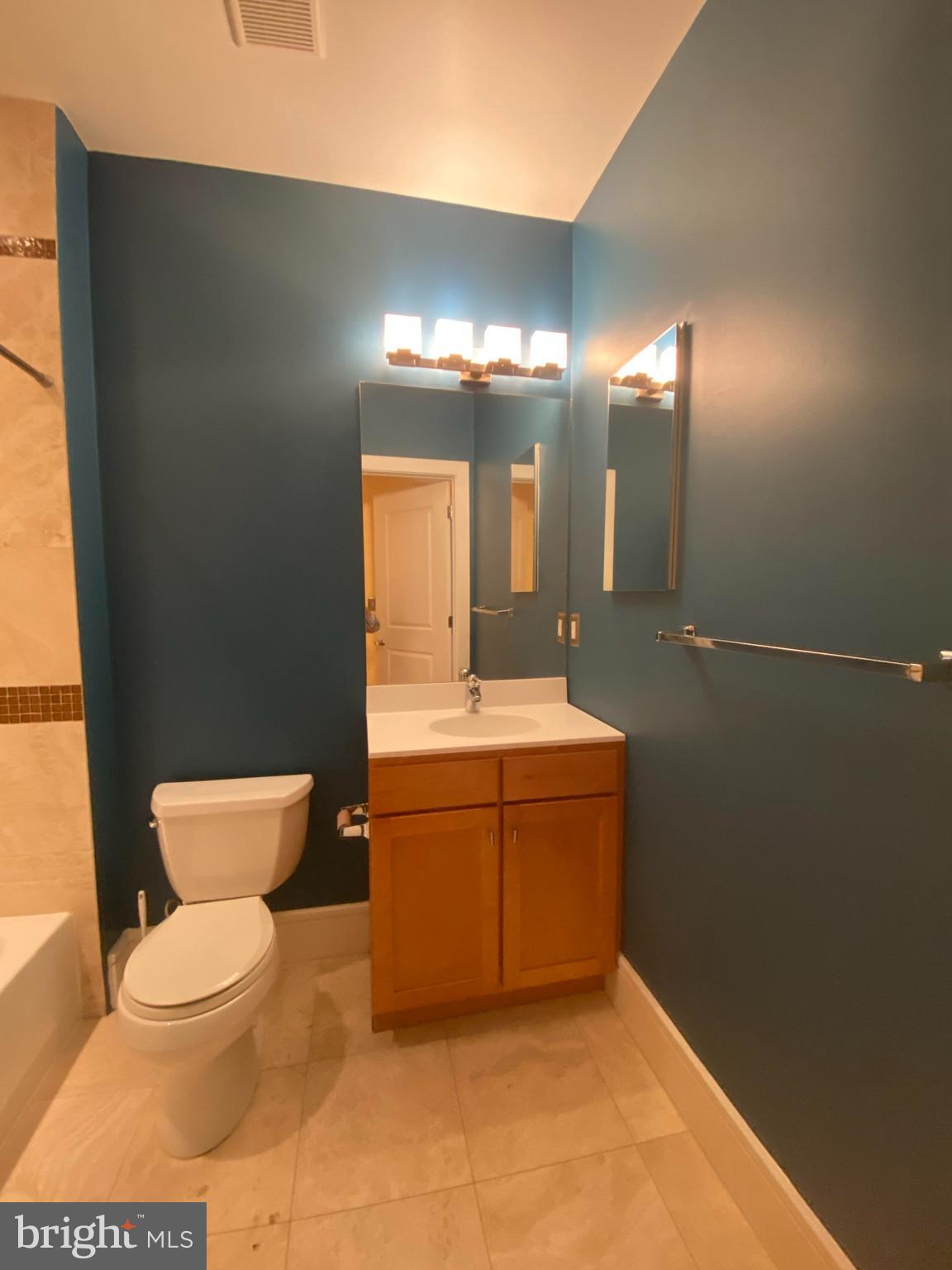 1654 Euclid Street Northwest, Unit 105 Washington, DC 20009 - Photo 23 of 29 a bathroom with a toilet a sink and mirror