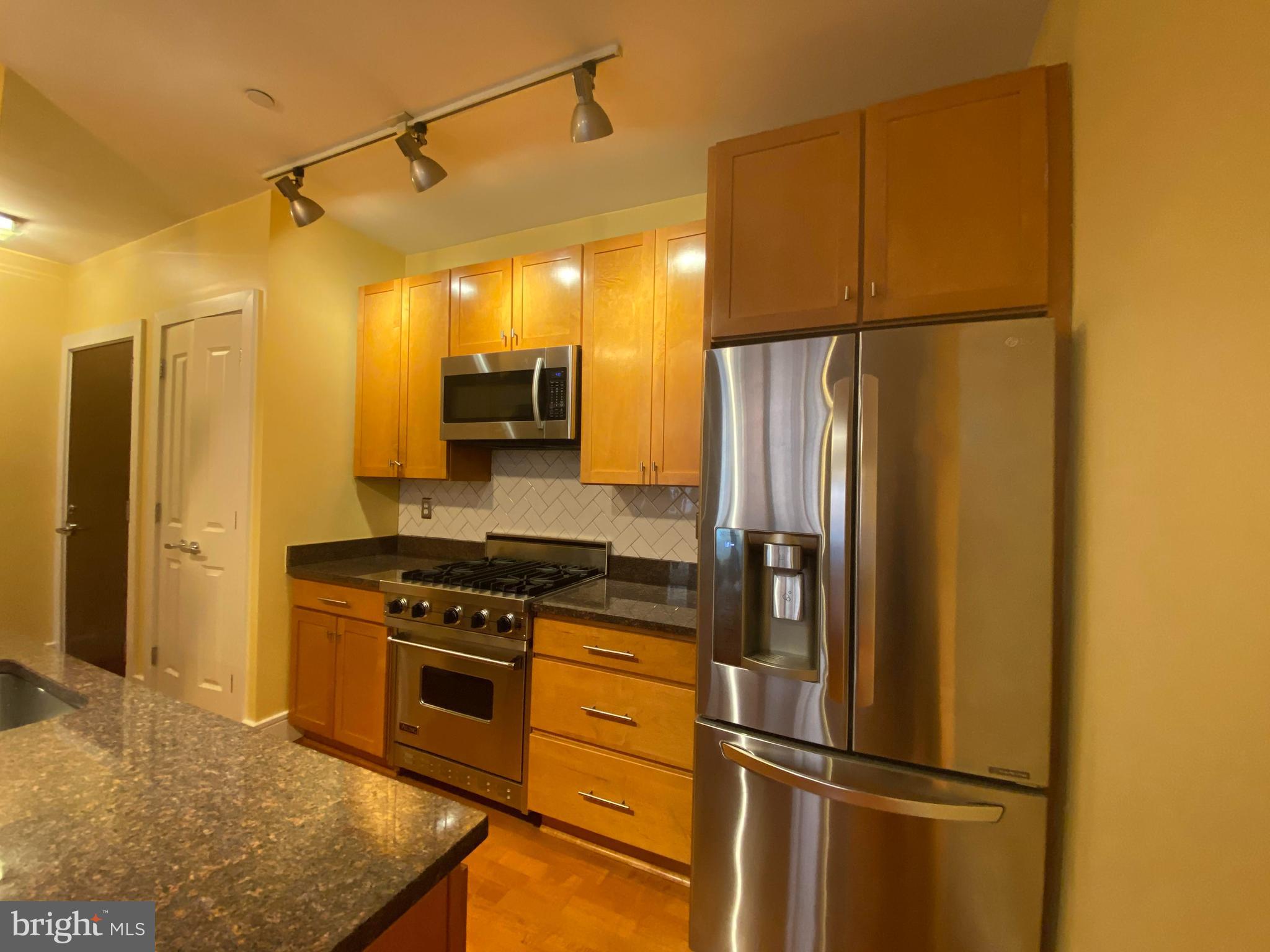 1654 Euclid Street Northwest, Unit 105 Washington, DC 20009 - Photo 8 of 29 a kitchen with a refrigerator a stove and a sink