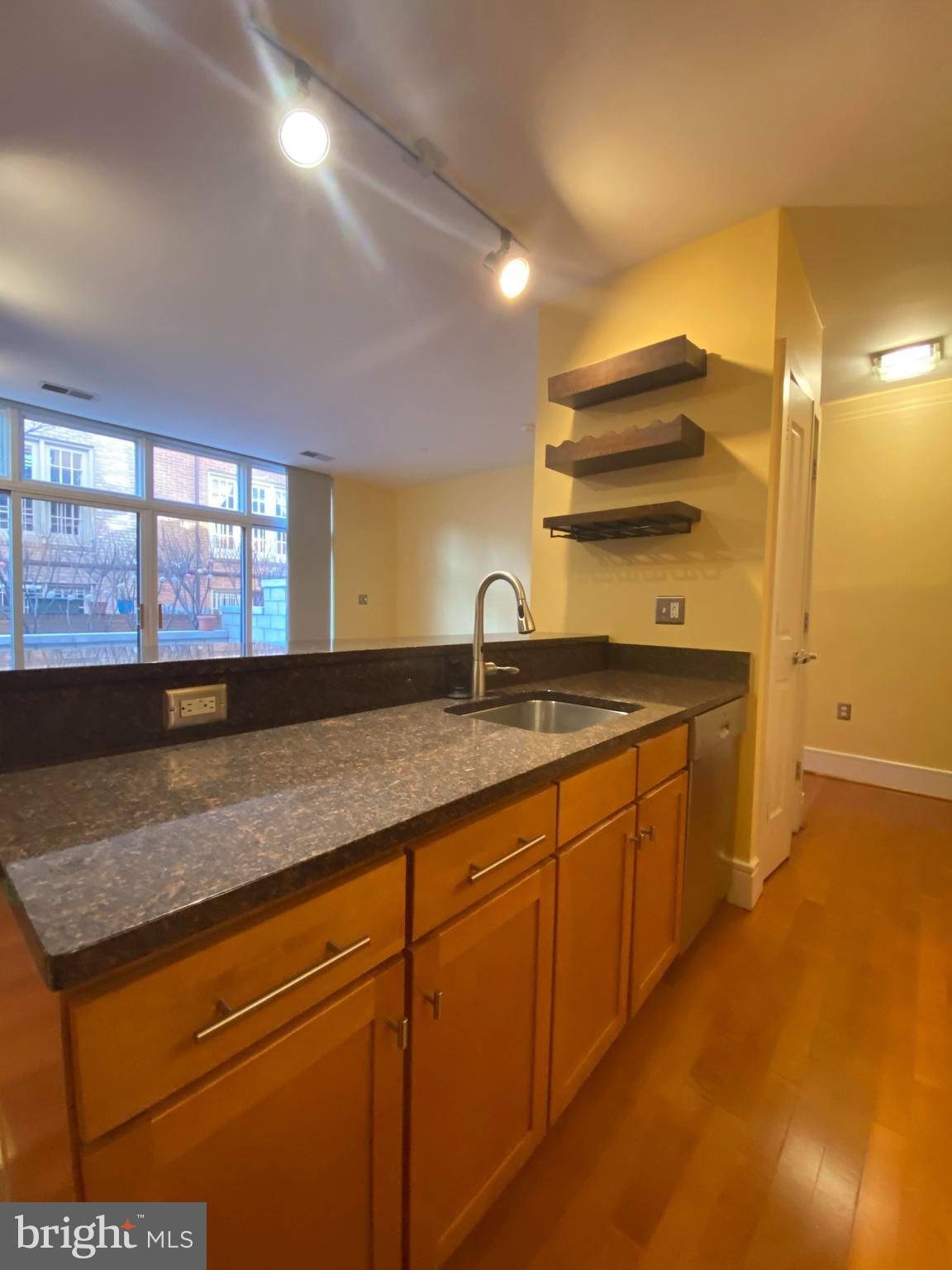 1654 Euclid Street Northwest, Unit 105 Washington, DC 20009 - Photo 9 of 29 a kitchen with stainless steel appliances granite countertop a sink and a wooden cabinets