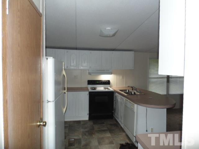 4522 Thomas Road Henderson, NC 27537 - Photo 13 of 19 a kitchen with a stove and a refrigerator