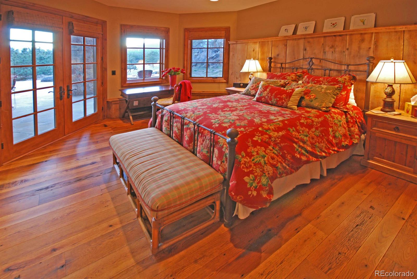 2127 Wieler Road Evergreen, CO 80439 - Photo 28 of 35 a bedroom with a bed a bookshelf and wooden floor