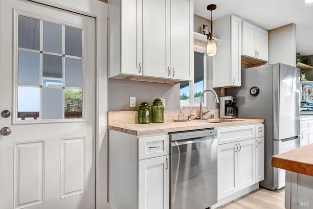 a kitchen with white cabinets and a refrigerator