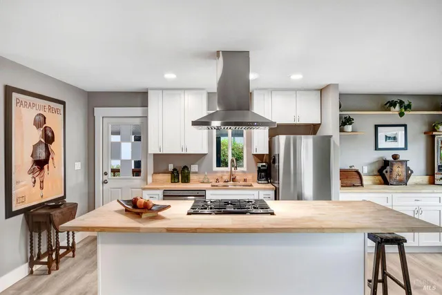 a kitchen with stainless steel appliances kitchen island granite countertop a dining table and chairs