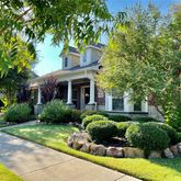 a front view of a house with a yard and potted plants