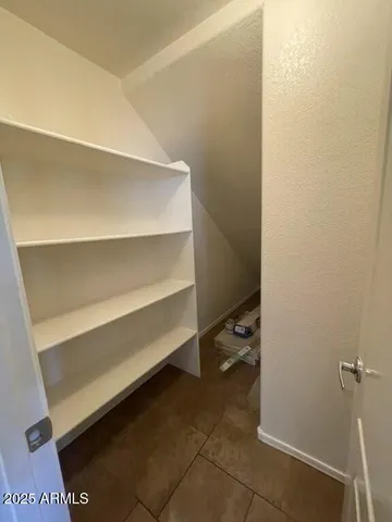 a view of walk in closet with empty racks