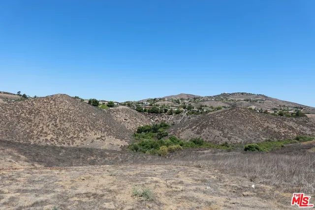 a view of a dry yard with mountains in the background