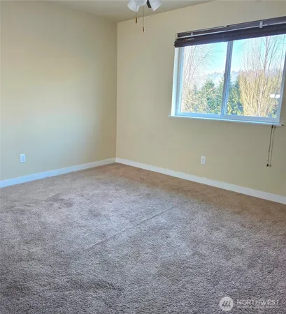 a view of an empty room with a ceiling fan
