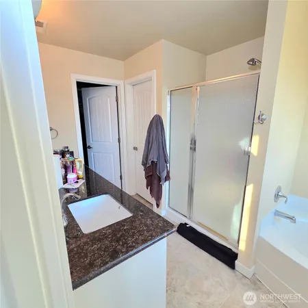 a bathroom with a tub a window and a shower