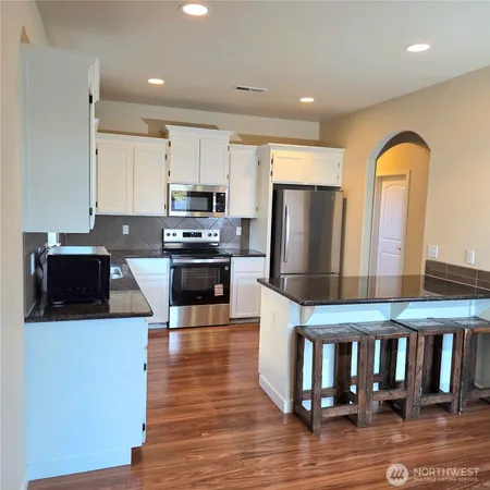 a kitchen with stainless steel appliances granite countertop a refrigerator a stove top oven a sink and dishwasher