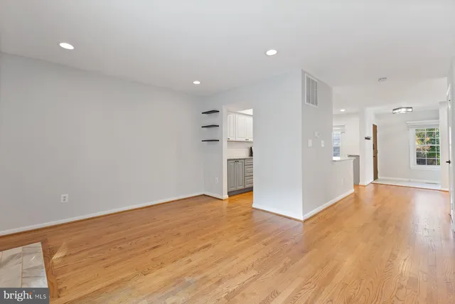 a view of a livingroom with a ceiling fan & windows