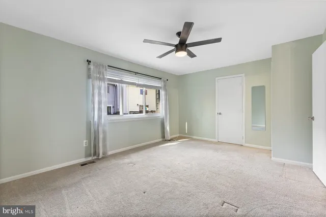 a view of a livingroom with a ceiling fan and window