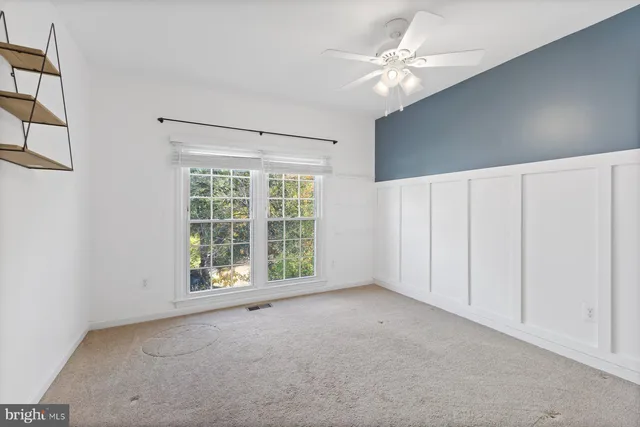 a view of an empty room with a chandelier fan