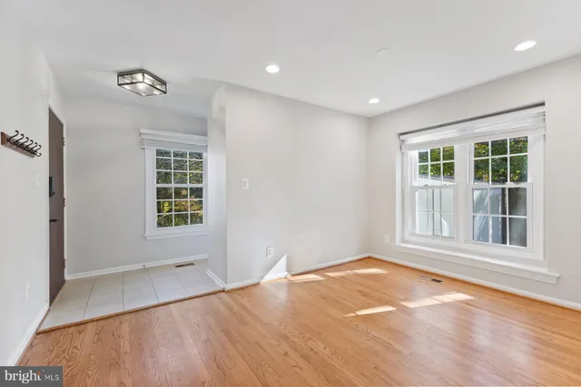 a view of empty room with a window and wooden floor
