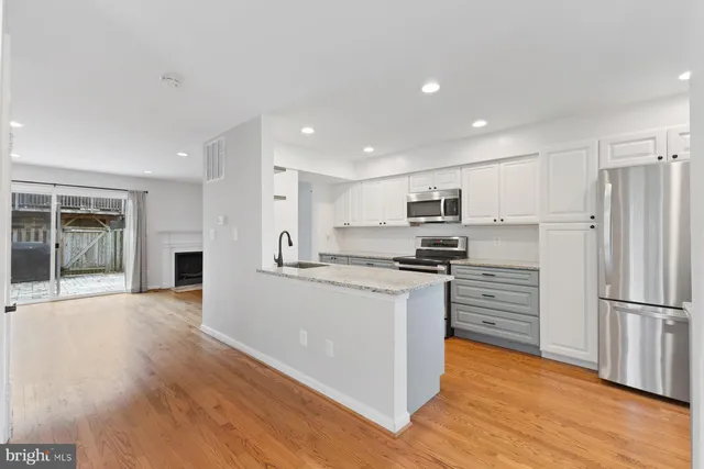a kitchen with stainless steel appliances granite countertop a refrigerator and a stove top oven