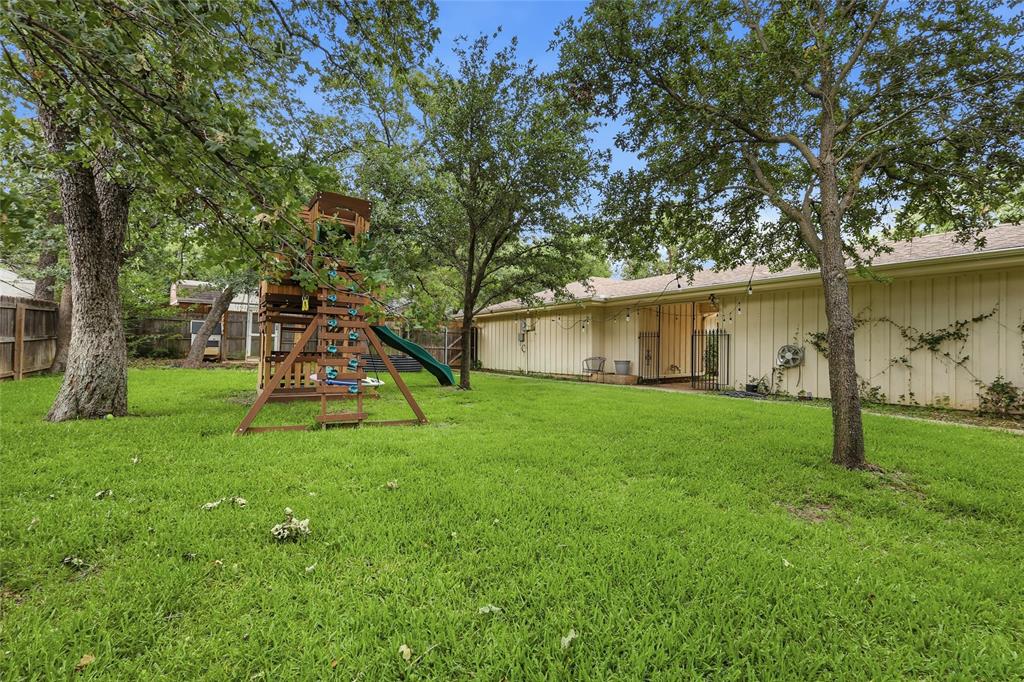 823 Ridgecrest Circle Denton, TX 76205 - Photo 38 of 40 Expansive green lawn with mature trees and a fenced perimeter