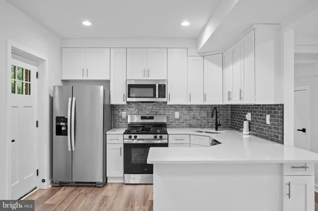 a kitchen with a sink a microwave a refrigerator and cabinets