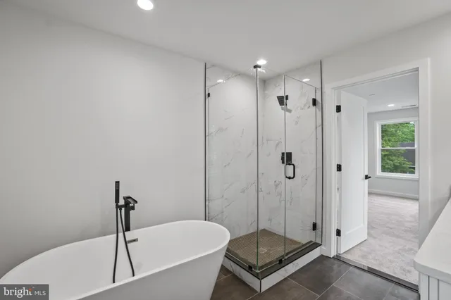 a bathroom with a tub shower and window