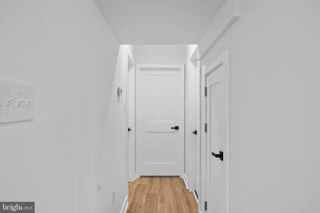 a view of a hallway with wooden floor and closet