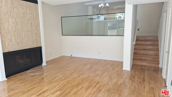 a view of a hallway with wooden floor and cabinet