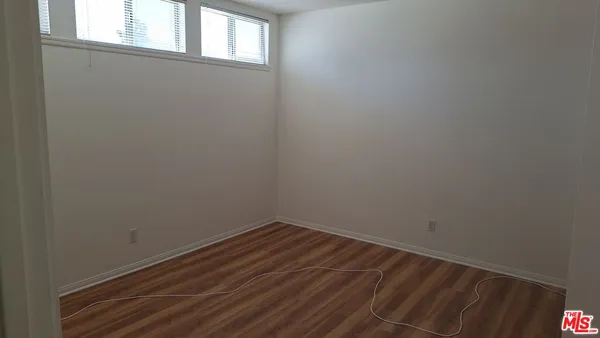 a view of a small space with wooden floor and a window