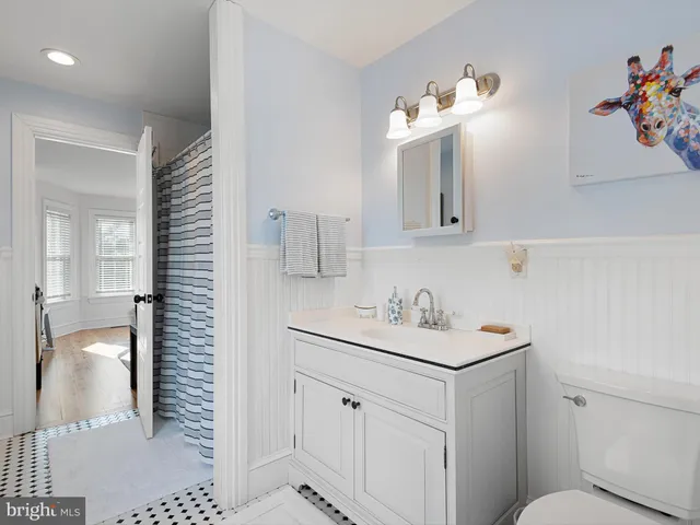 a bathroom with a sink a toilet and mirror