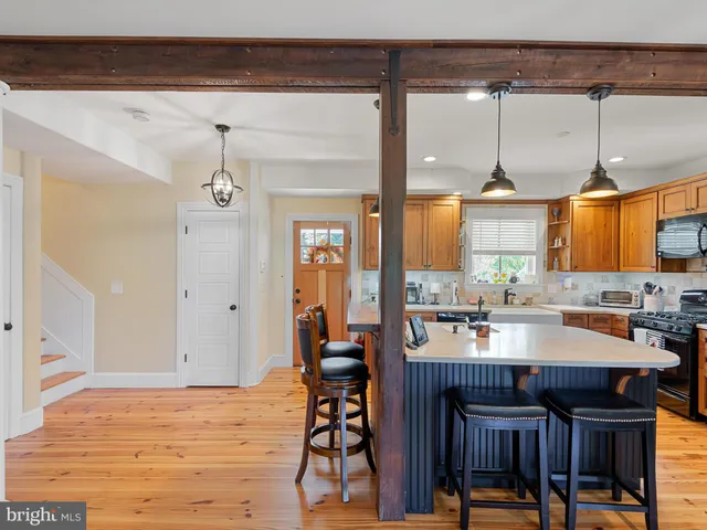 a kitchen with granite countertop a table chairs stove and wooden floor