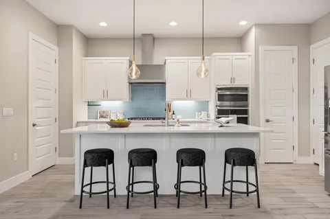 a kitchen with cabinets and chairs