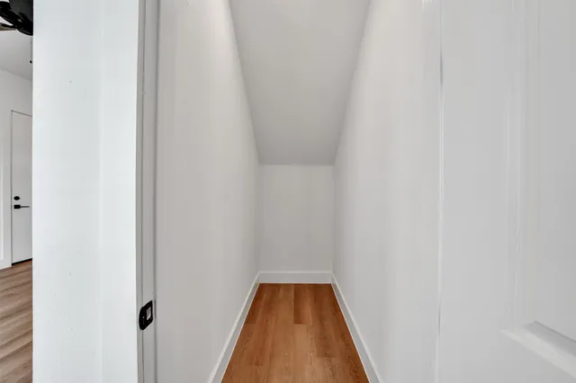 a view of a hallway with wooden floor