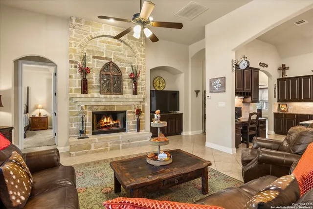 a living room with furniture a fireplace and a chandelier