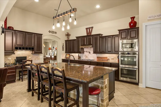a kitchen with stainless steel appliances granite countertop a stove refrigerator and cabinets