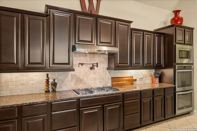 a kitchen with stainless steel appliances granite countertop a sink stove and cabinets