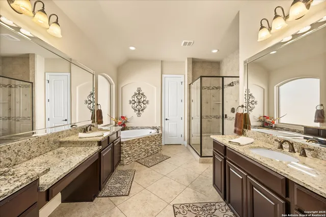 a large bathroom with a granite countertop double vanity sink mirror and shower