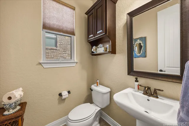 a bathroom with a toilet a sink and mirror