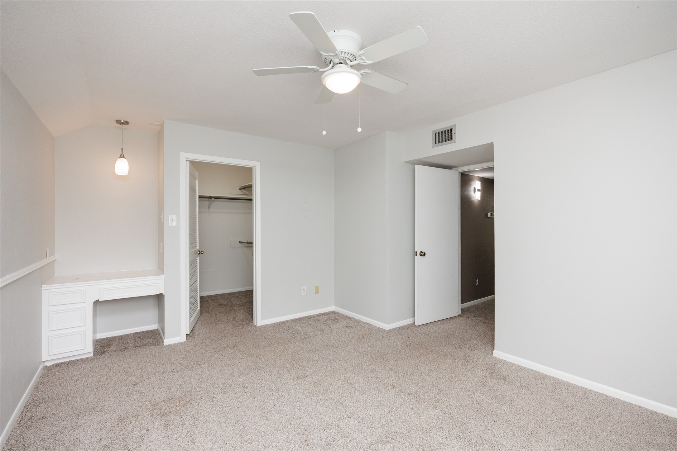 320 Long Point Drive Portland, TX 78374 - Photo 20 of 40 Carpeted room featuring a ceiling fan with integrated lighting, a built-in desk with drawers, a pendant light fixture, and two doorways, one opening to a closet with shelving
