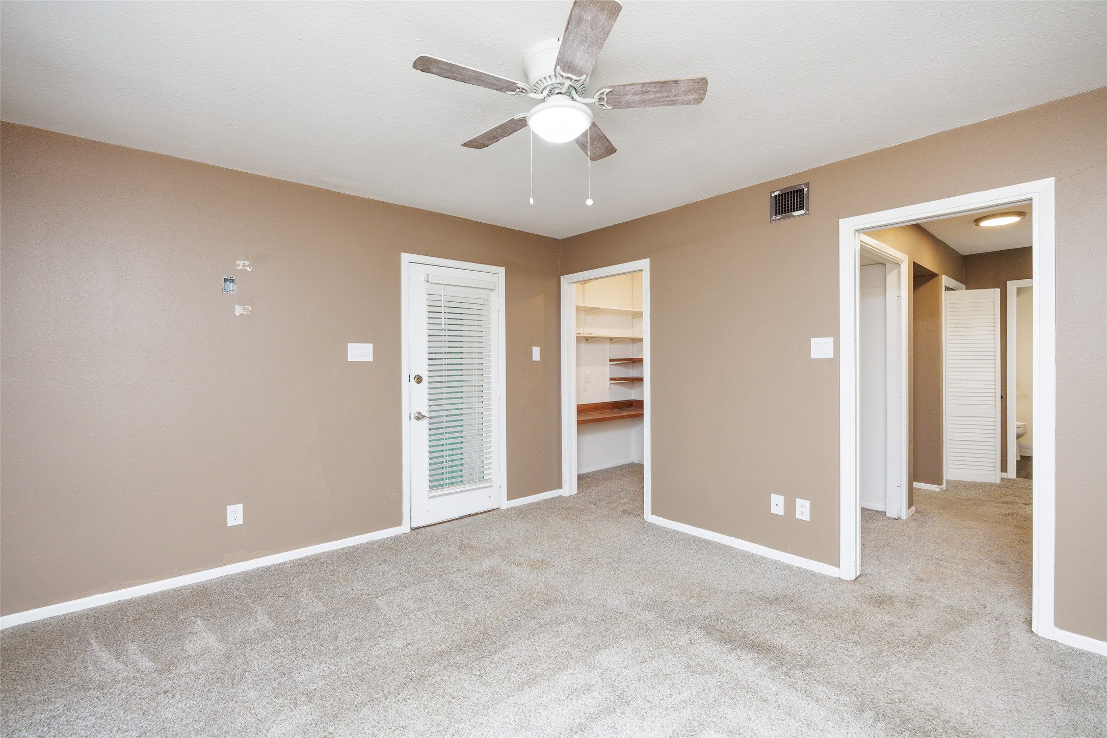 320 Long Point Drive Portland, TX 78374 - Photo 26 of 40 Carpeted room featuring a ceiling fan with light fixture, a door with integrated blinds, and multiple doorways including one to a closet with built-in shelving
