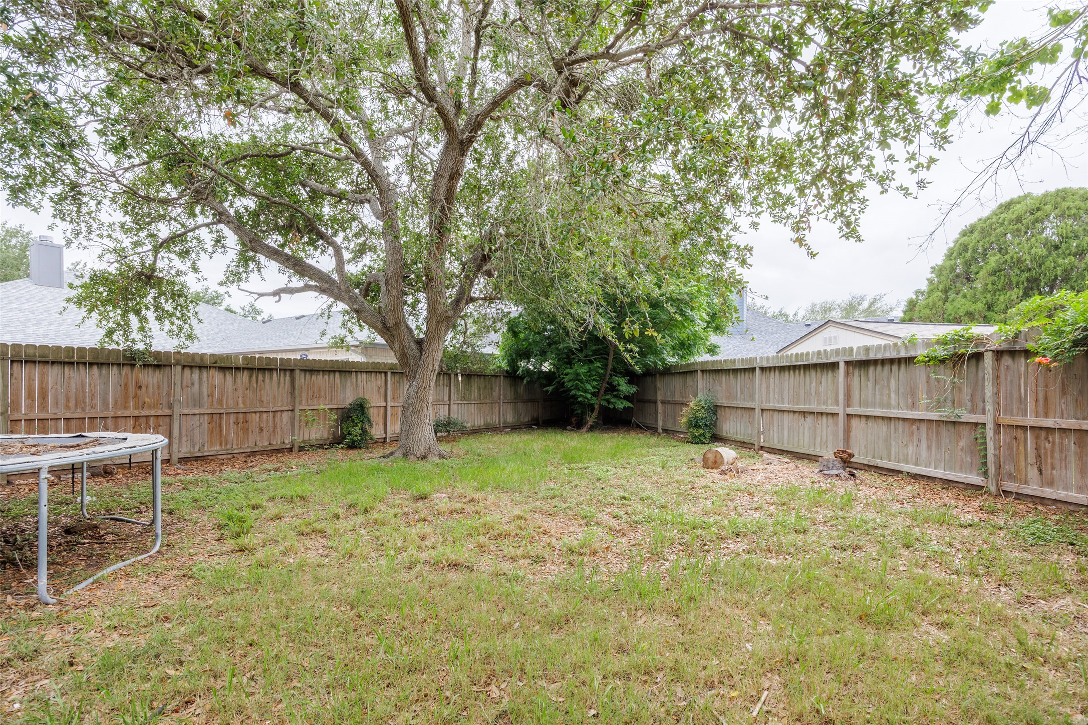 320 Long Point Drive Portland, TX 78374 - Photo 35 of 40 Expansive backyard featuring a mature tree, natural grass, and complete wood privacy fencing