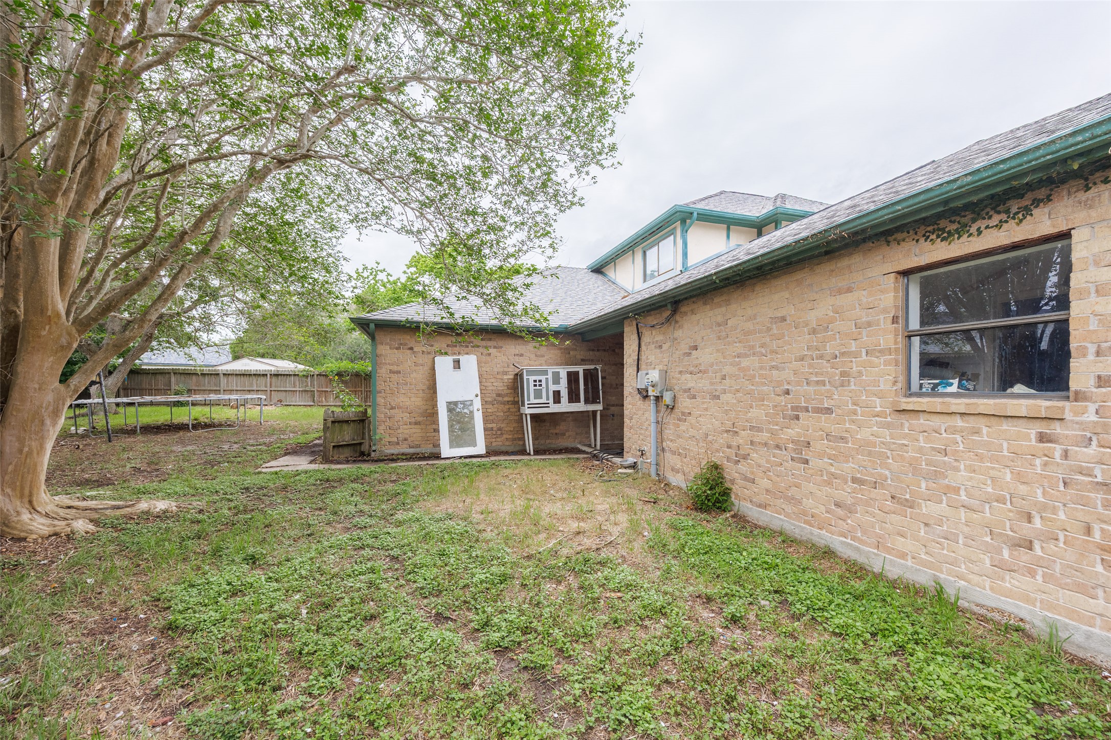 320 Long Point Drive Portland, TX 78374 - Photo 36 of 40 Expansive rear yard featuring mature trees and a brick exterior building with a shingle roof