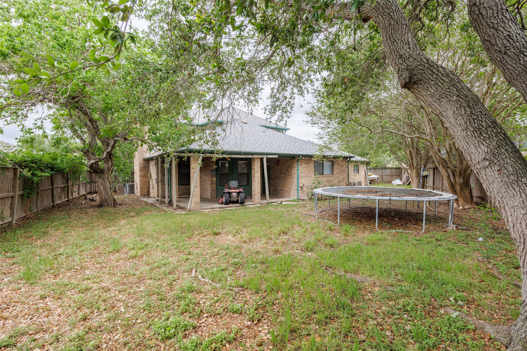 320 Long Point Drive Portland, TX 78374 - Photo 37 of 40 Expansive backyard featuring mature trees, a brick exterior, covered patio, and a shingle roof