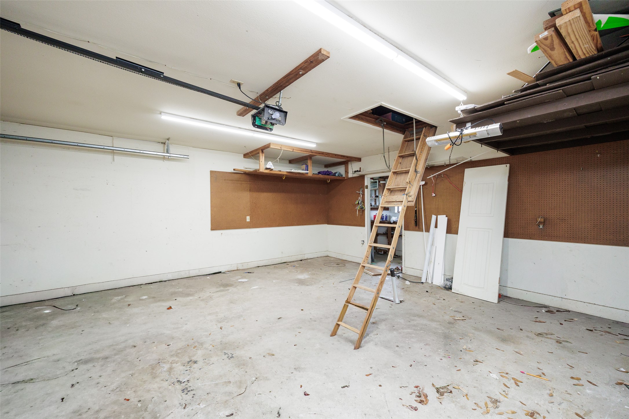 320 Long Point Drive Portland, TX 78374 - Photo 38 of 40 Spacious garage with concrete flooring, fluorescent lighting, and a built-in attic access ladder