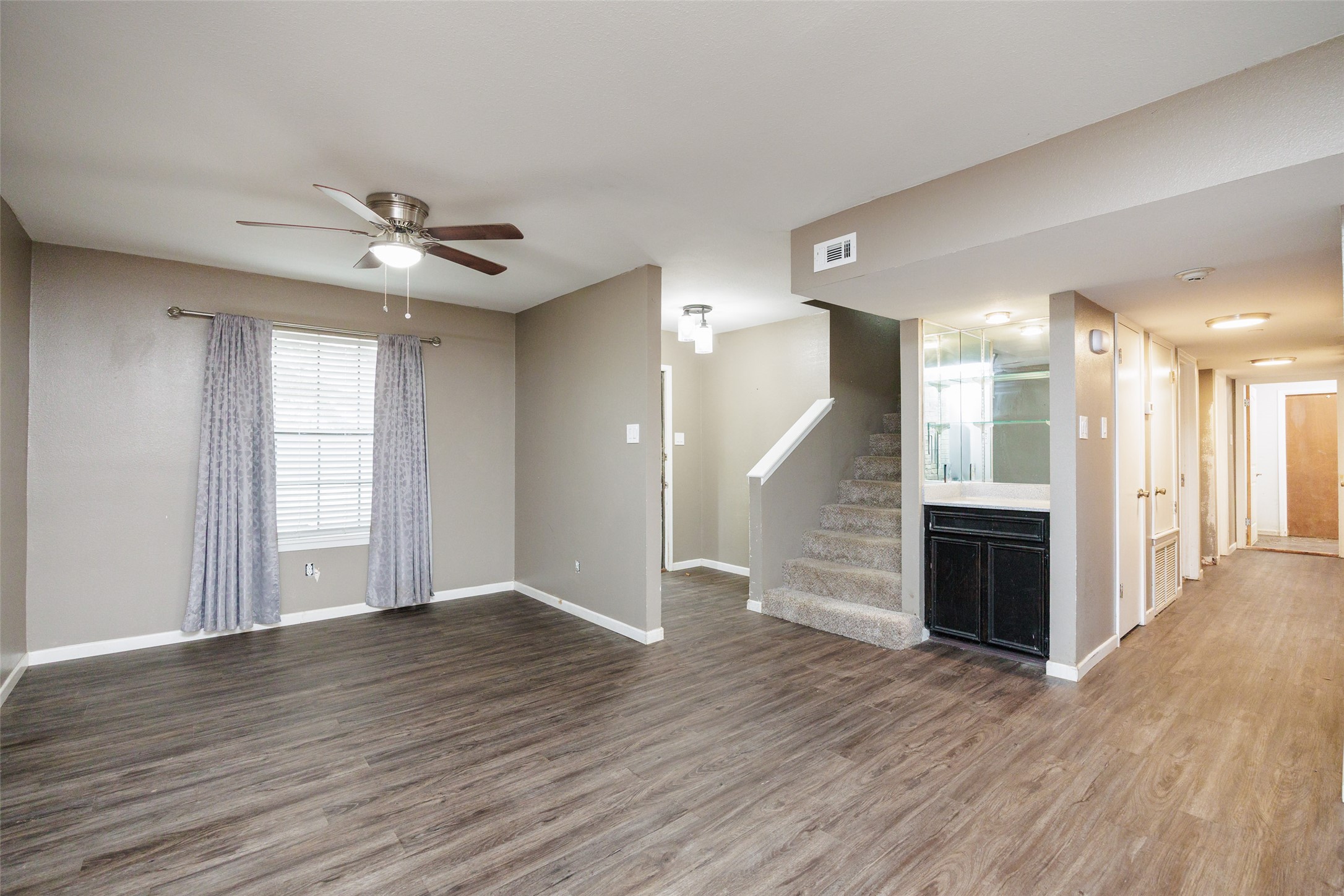 320 Long Point Drive Portland, TX 78374 - Photo 4 of 40 This perspective showcases the versatility of the main level, highlighting the staircase transition and a built-in wet bar perfect for entertaining guests in the heart of the home.
