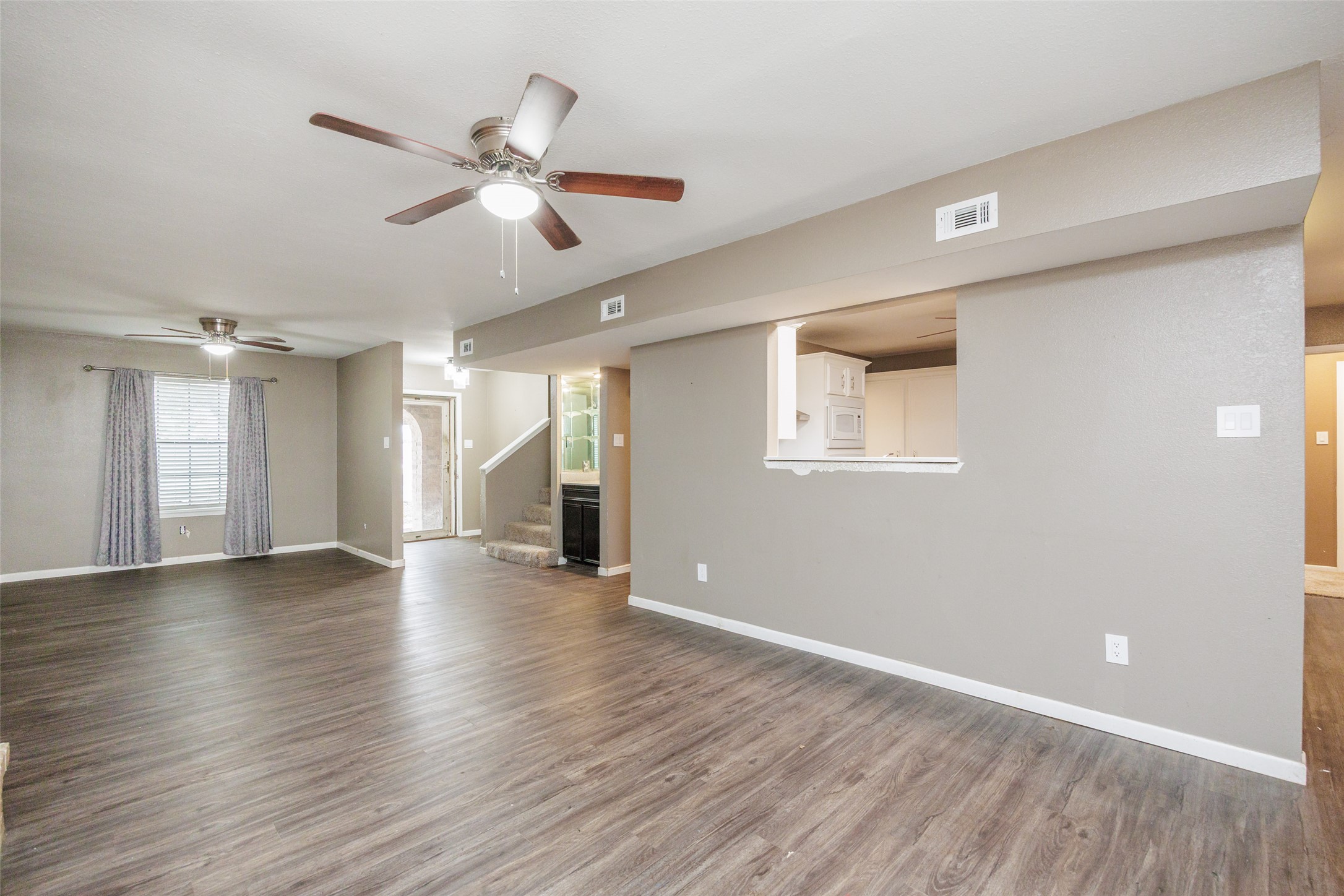 320 Long Point Drive Portland, TX 78374 - Photo 5 of 40 The living area maintains a spacious feel while staying connected to the kitchen through a large pass-through window, perfect for keeping the conversation going while preparing meals.
