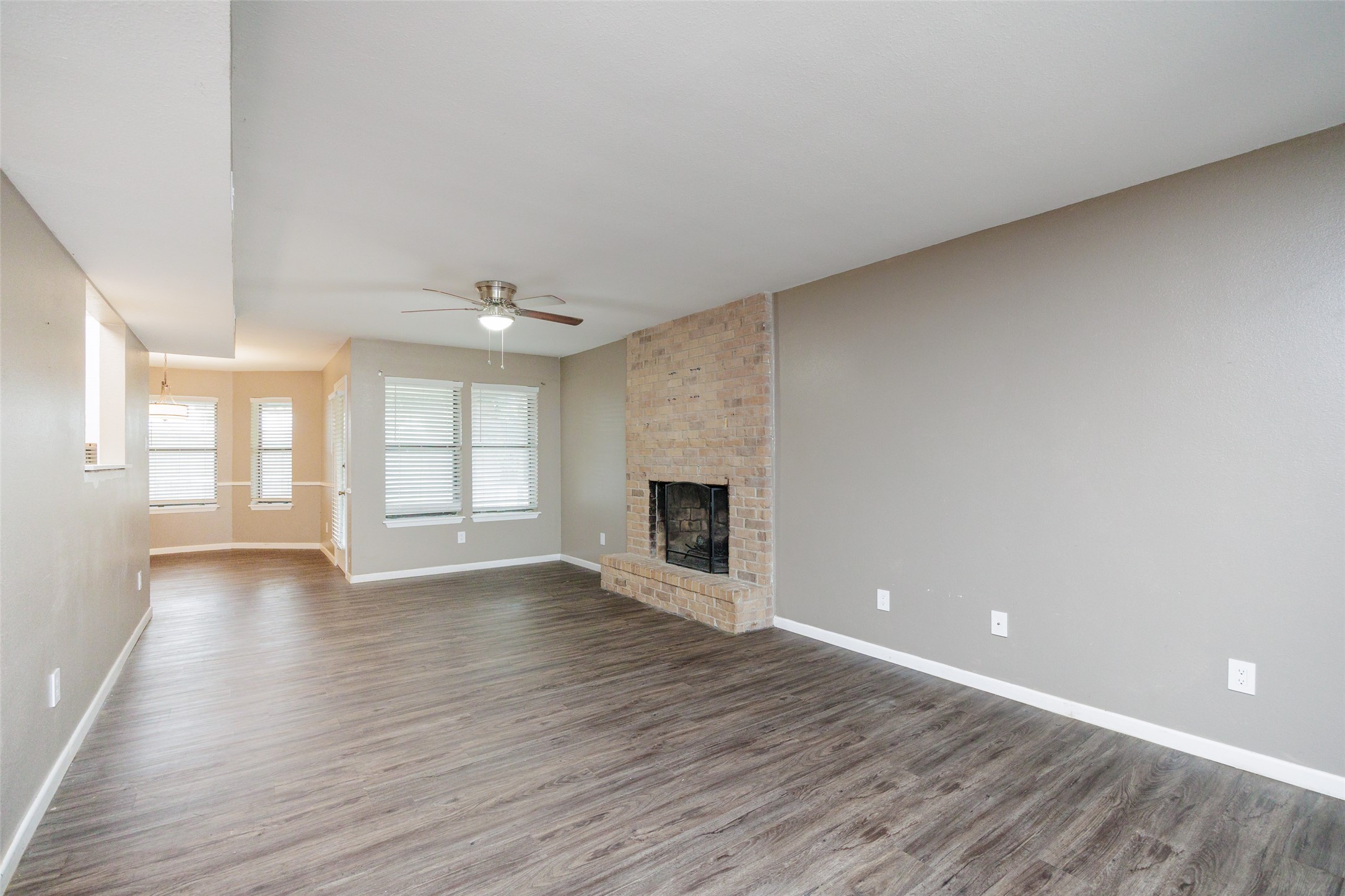 320 Long Point Drive Portland, TX 78374 - Photo 6 of 40 A floor-to-ceiling brick fireplace serves as the warm focal point of the living room, adding a touch of timeless texture to the modern flooring and neutral palette.