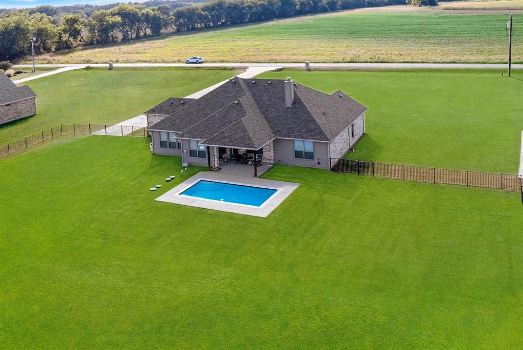 634 Gant Road Sherman, TX 75090 - Photo 37 of 40 Extensive green lawn surrounding a residence with a dark shingle roof and a built-in rectangular swimming pool