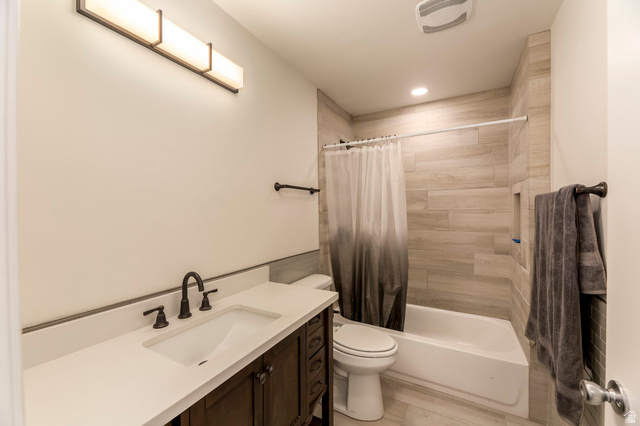 4658 Box Elder Street Salt Lake City, UT 84107 - Photo 4 of 17 Bathroom featuring a full vanity with a white countertop and undermount sink, dark bronze hardware, a white bathtub with a tiled surround, and recessed lighting
