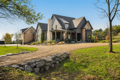 a front view of a house with a yard and trees