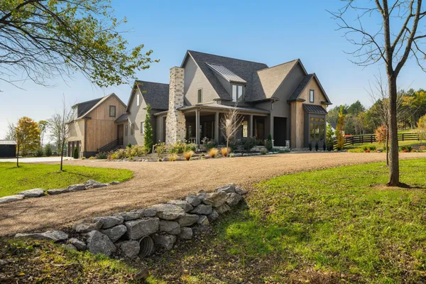 a front view of a house with a yard and trees